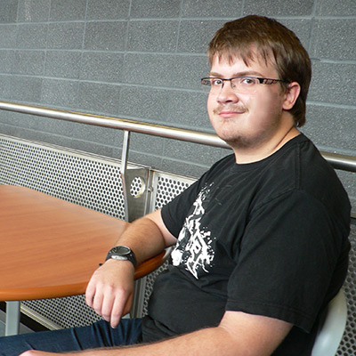 une photo de moi, cheveux châtains, yeux bruns, un jeune homme, porte des lunettes